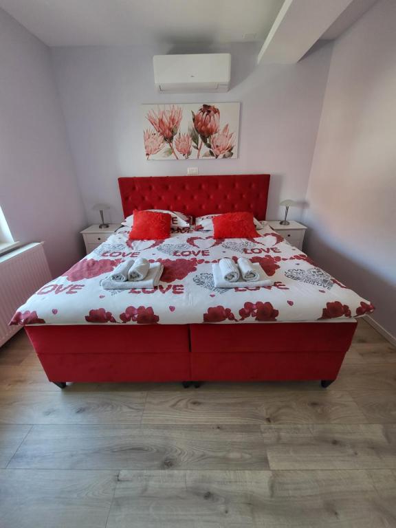 1 dormitorio con cama roja y almohadas rojas en Villa Vino & Grad, en Zagreb