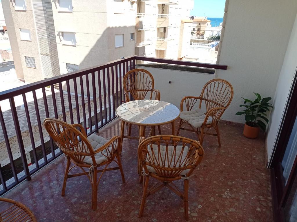 balcón con mesa, sillas y ventana en Nereidas Solo Familias SERVIPLAYA, en Casas Las Basas