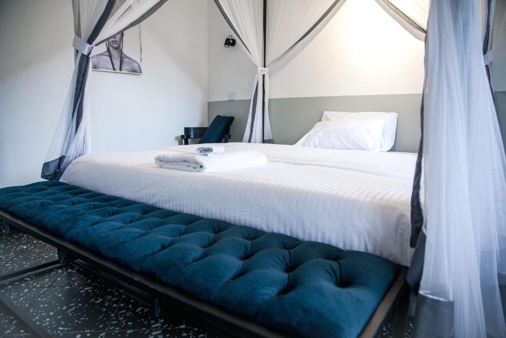 1 dormitorio con 1 cama grande y banco azul en Explorers Hub en Kampala