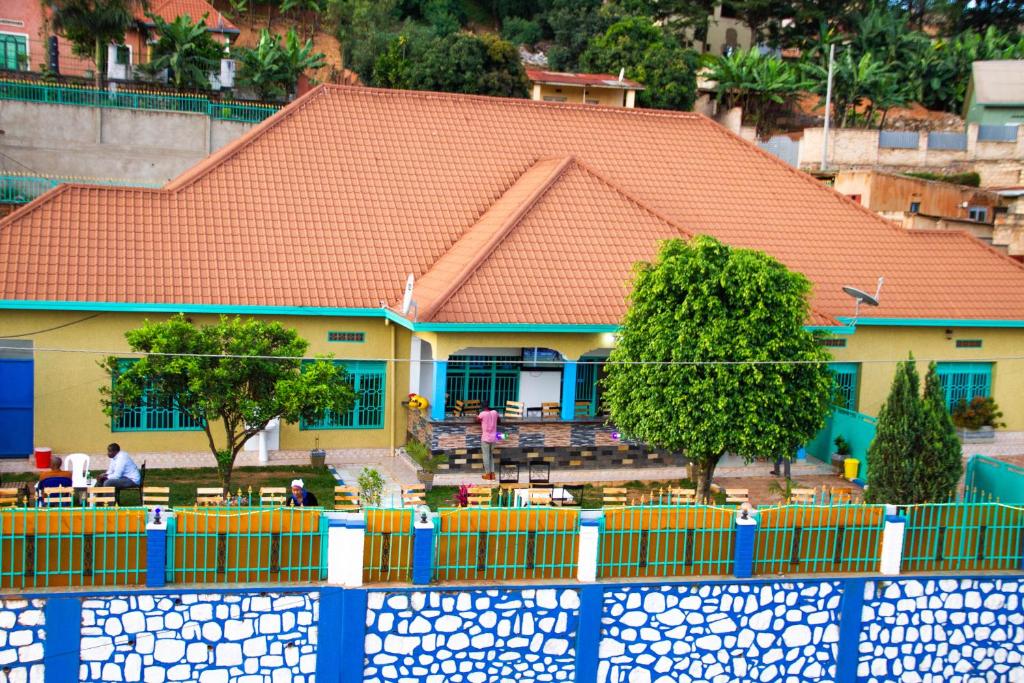 ein Haus mit einem orangenen Dach und einem blauen Zaun in der Unterkunft Branice Guest House in Kigali