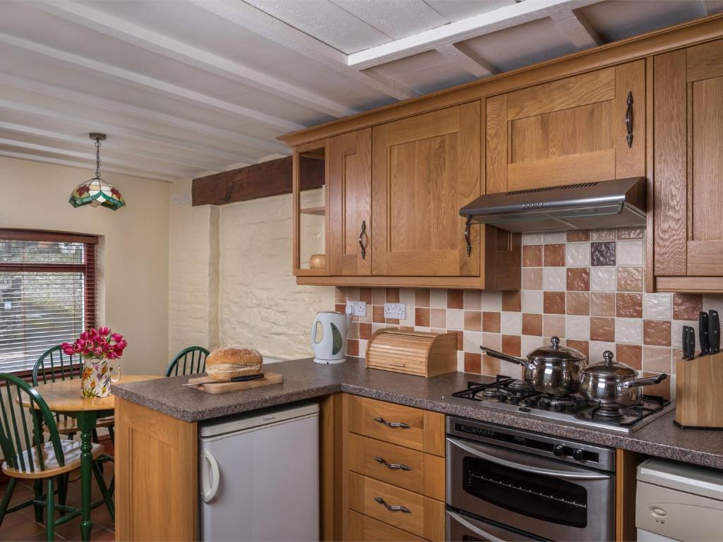 a kitchen with wooden cabinets and a stove top oven at 1 Bed in Bwlch BN367 in Bwlch