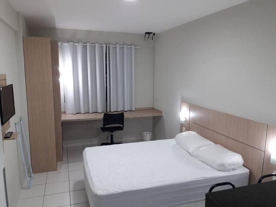 1 dormitorio con cama, escritorio y silla en Flat para temporada Caruaru, en Caruaru