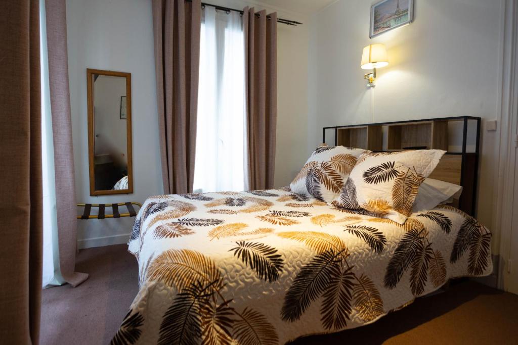 una camera da letto con un letto con un piumone di Ideal Hotel a Parigi