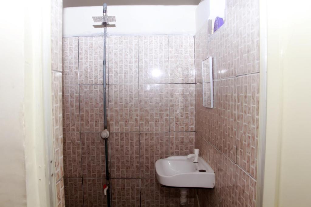een kleine badkamer met een wastafel en een douche bij Smilley's Place Szilvie in Lagos