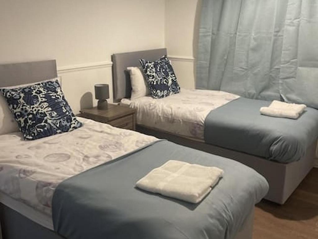 a bedroom with two beds with towels on top at Tms 3bdr Tilbury - Free Parking in Tilbury