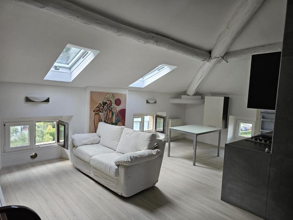 sala de estar con sofá blanco y mesa en Casa Laura - Riva del Garda, en Riva del Garda