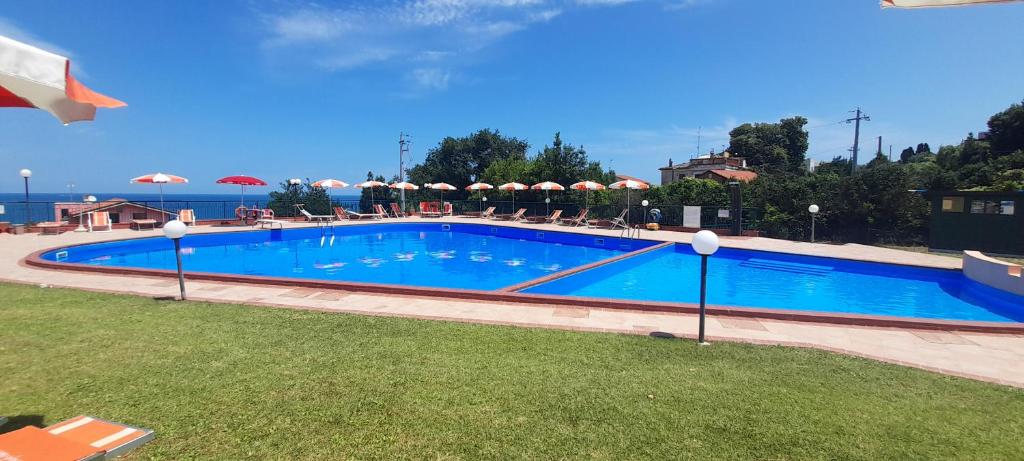 a large swimming pool with chairs and umbrellas at La Via dei Trabocchi in San Vito Chietino