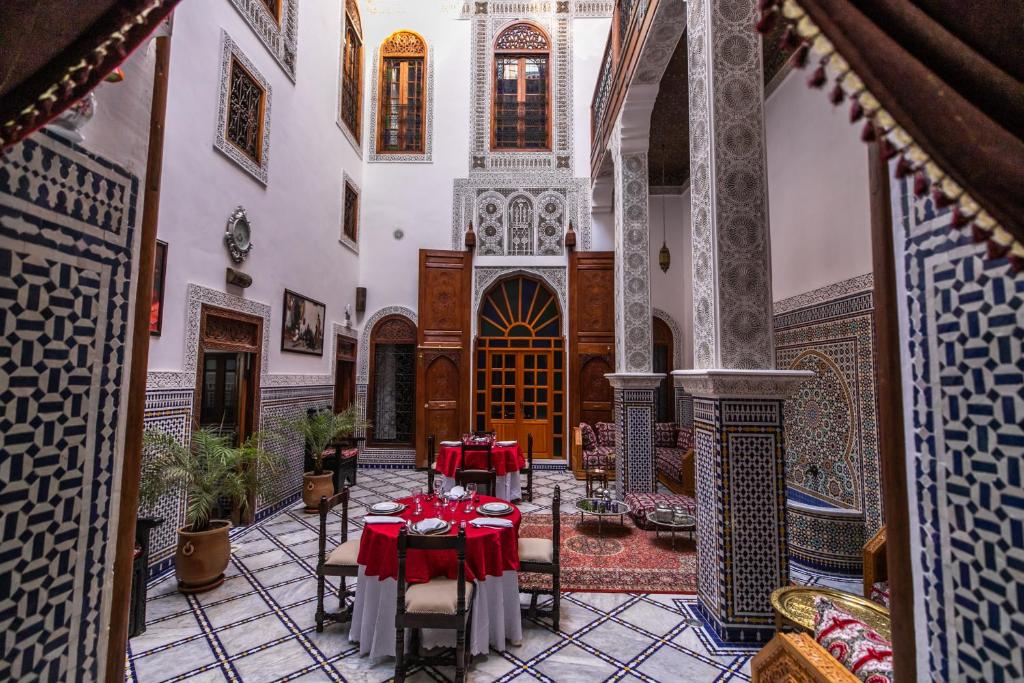 a courtyard with tables and chairs in a building at Riad Jamal in Fez