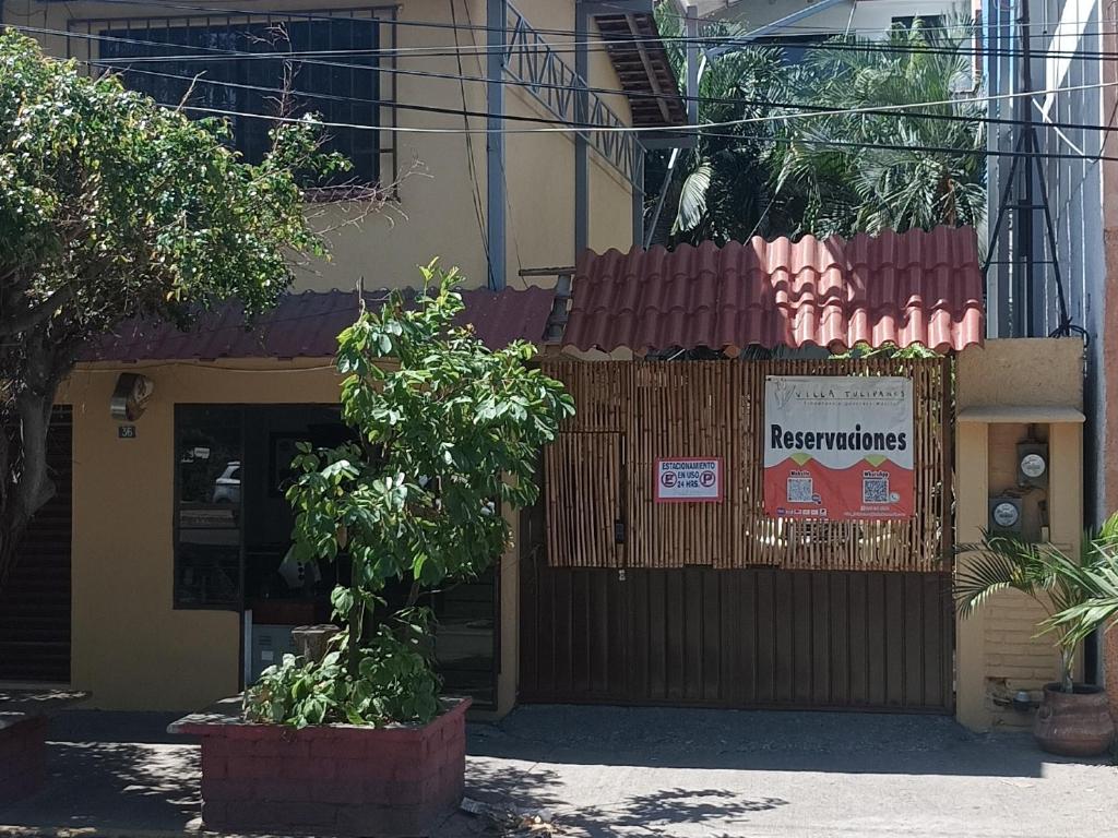 un restaurante con un cartel en el lateral de un edificio en Hotel Villa Tulipanes, en Zihuatanejo