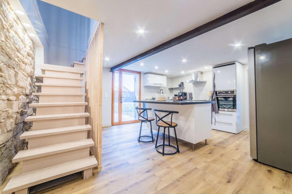 uma escada que leva a uma cozinha com um balcão em BOYER 3 - Maison Terrasson - 3 chambres em Terrasson