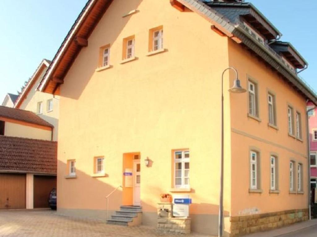 ein gelbes Gebäude mit Straßenbeleuchtung davor in der Unterkunft Gästehaus Ritter in Sinsheim