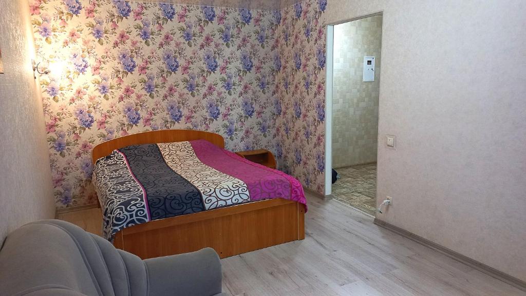 a bedroom with a bed with a floral wallpaper at Apartment - Generala Petrova Street in Odesa