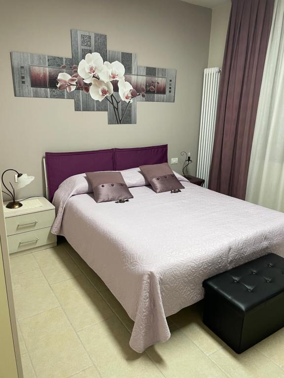 1 dormitorio con 1 cama grande y un jarrón con flores en La casetta di Sally, en Ca Falier