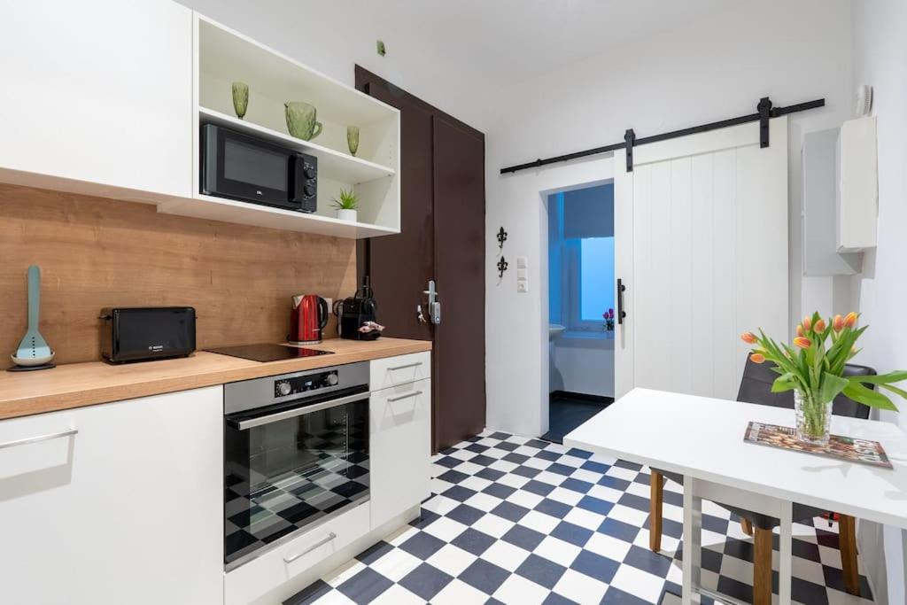 cocina con armarios blancos y suelo a cuadros en HM • Practical 1BR Flat by Center, en Viena