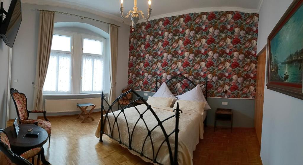 - une chambre avec un lit et un mur fleuri dans l'établissement Historischer Winzerverein Boutique B&B, à Senheim