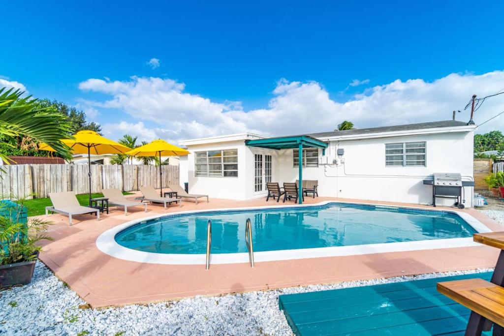 uma piscina com mobiliário de pátio e uma casa em Urban Chic Private Pool Home em Hollywood