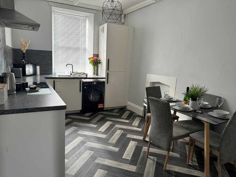 a kitchen and dining room with a table and chairs at Lowther House -2 Bed Apartment in Whitehaven