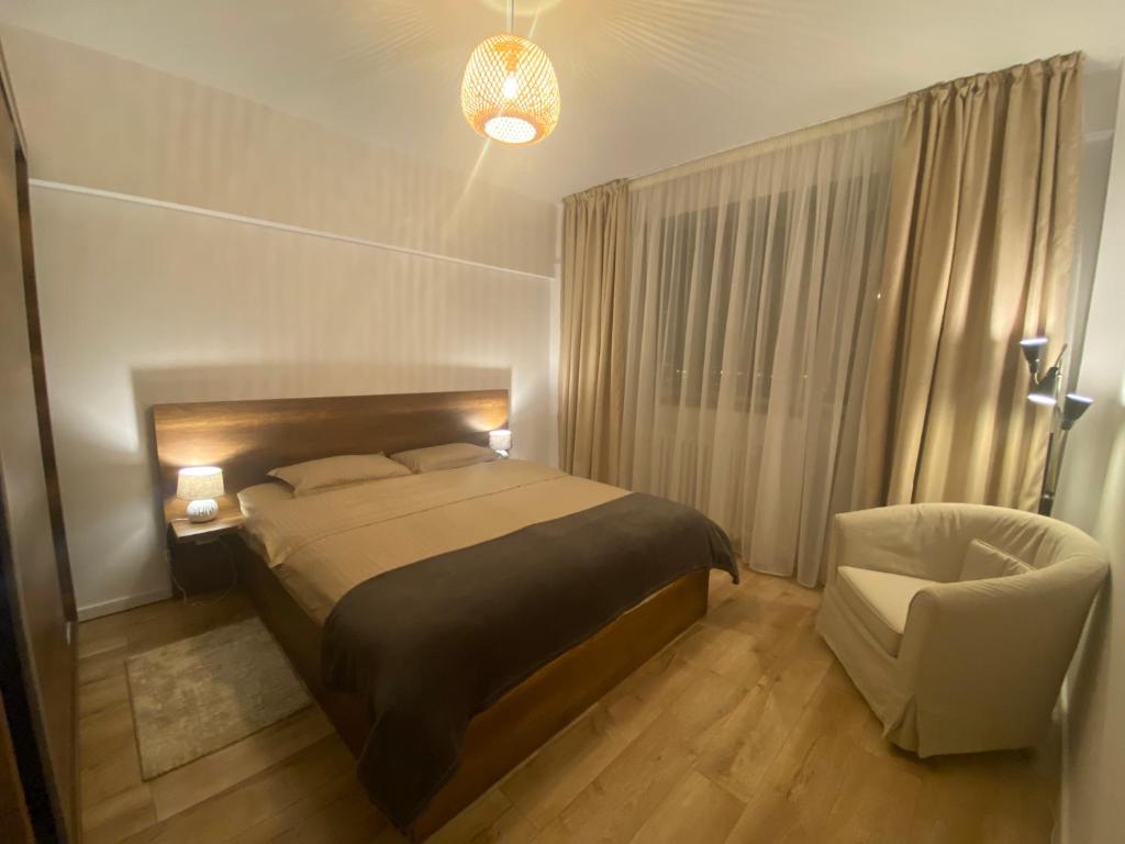 ein Schlafzimmer mit einem Bett und einem Stuhl in der Unterkunft Doinei Cozy Flat in Timişoara