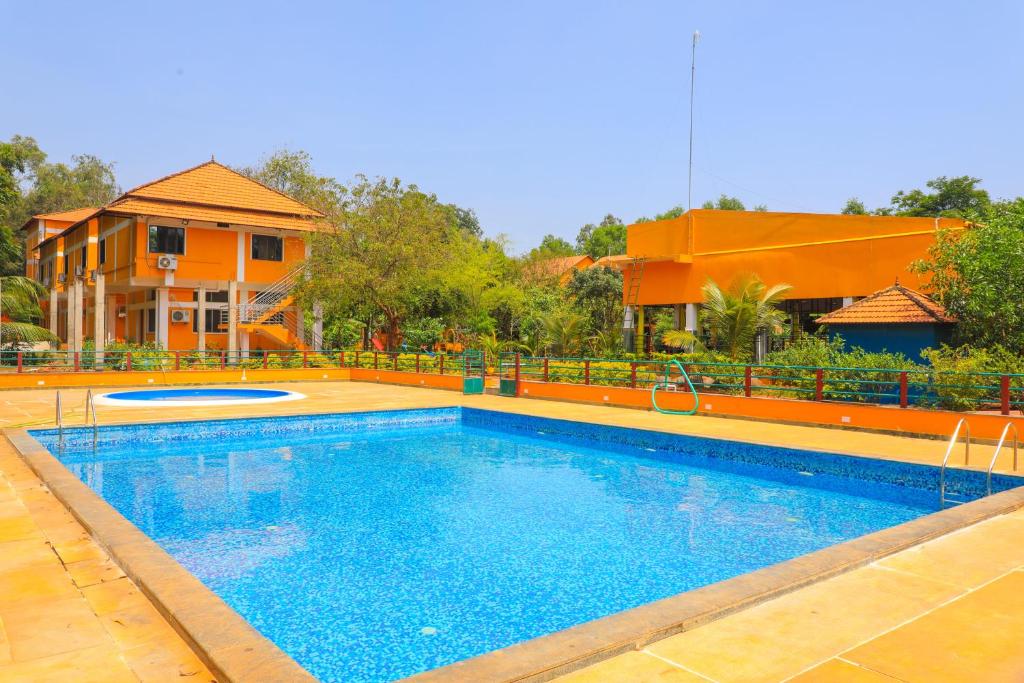 a large swimming pool in front of a house at Auro Wellness Castle in Puducherry