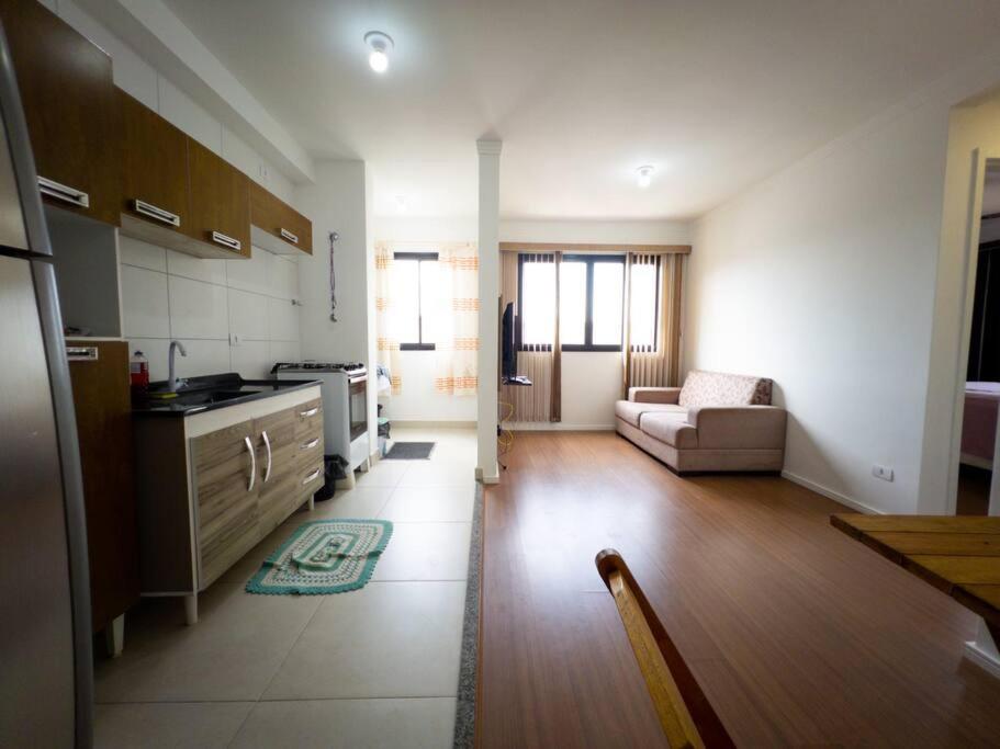 uma cozinha e sala de estar com um sofá e uma mesa em Apto Novo Prox. Hosp. Paraná Wi-Fi Fibra - AZ401 em Maringá