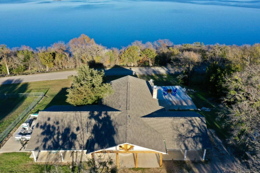 - une vue sur la maison et l'eau dans l'établissement Walk to Lake Whitney Fire Pit BBQ Grill King Bed, à Whitney