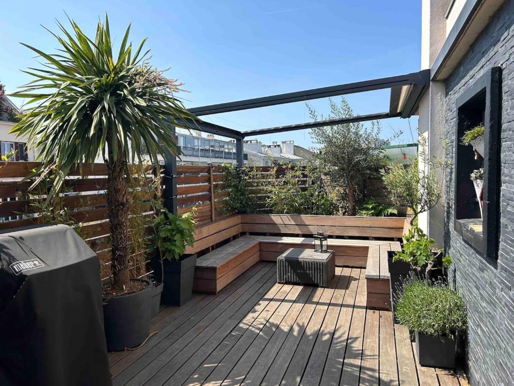un patio avec des plantes en pot dans un bâtiment dans l'établissement Appartement spacieux à Asnières-sur-Seine avec terrasse., à Asnières-sur-Seine
