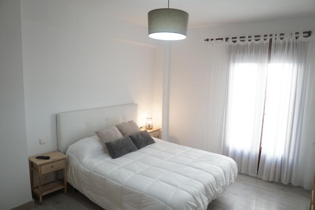 um quarto branco com uma cama branca e uma janela em Casa Fausto Lasarte-oria em Lasarte-Oria
