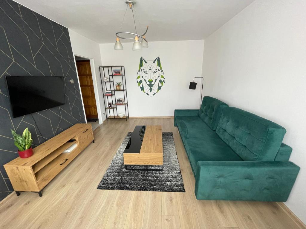 a living room with a green couch and a table at Apartament 11 Stogi in Gdańsk