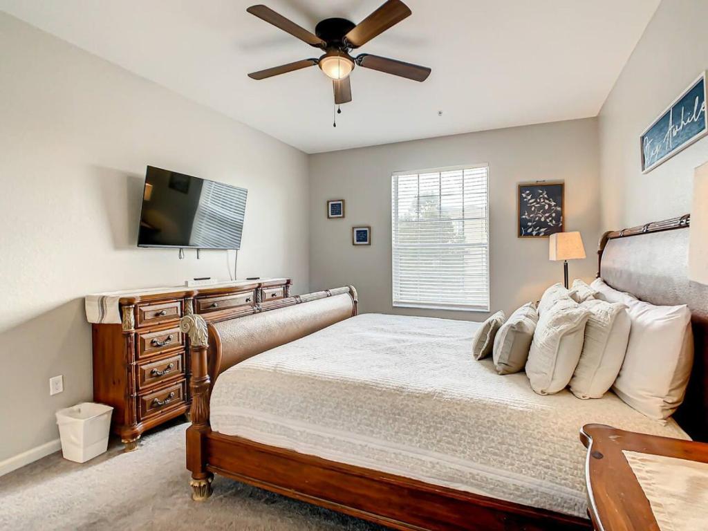 Schlafzimmer mit einem Bett und einem Flachbild-TV in der Unterkunft Windsor Hills Mickey Mouse Condo, 2.5mi Disney in Orlando