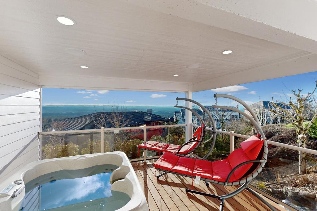 a balcony with two chairs and a hot tub at Hillside Sanctuary in Portland