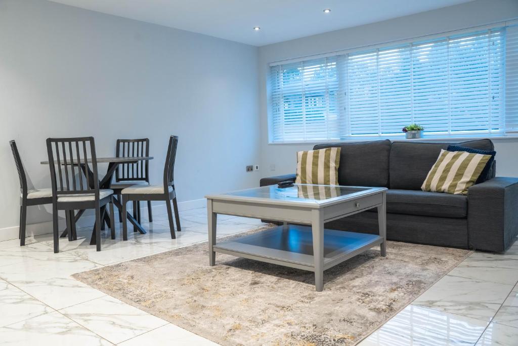 a living room with a couch and a table and chairs at Stunning 2-Bed Ground Floor Flat in Birmingham in Birmingham