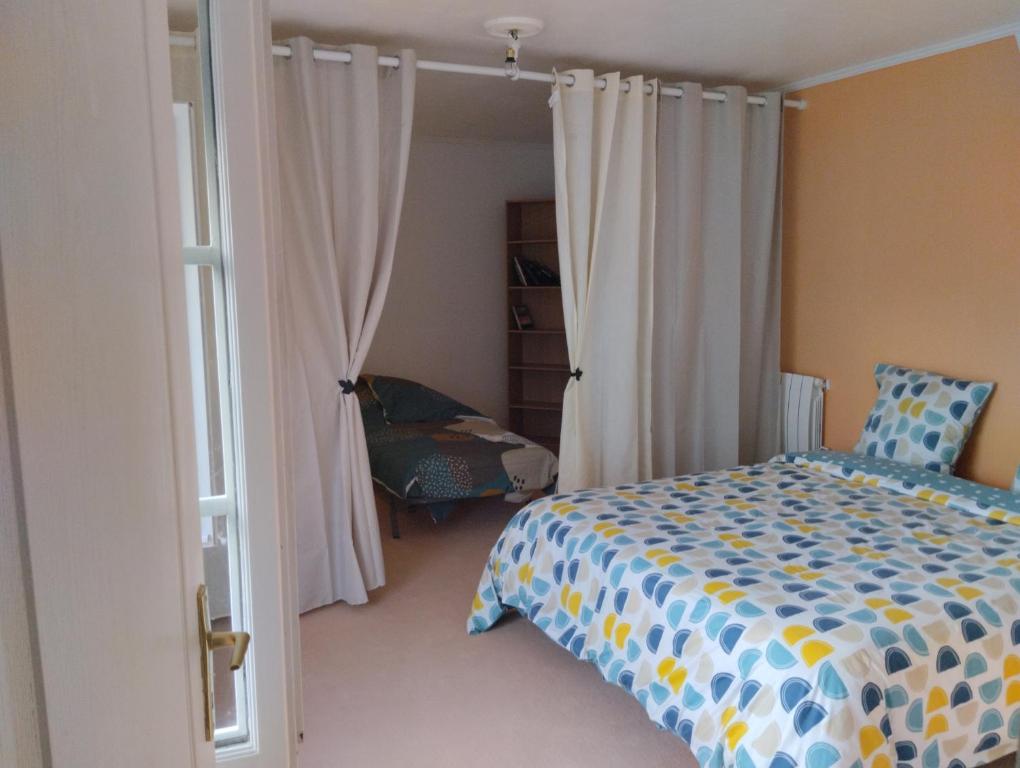 1 dormitorio con 1 cama y 1 silla en LA BELLE IVOIRE, en Saint-Marcel