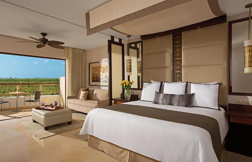 a bedroom with a large bed and a living room at Secrets Playa Mujeres Golf & Spa Resort - All Inclusive Adults Only in Cancún