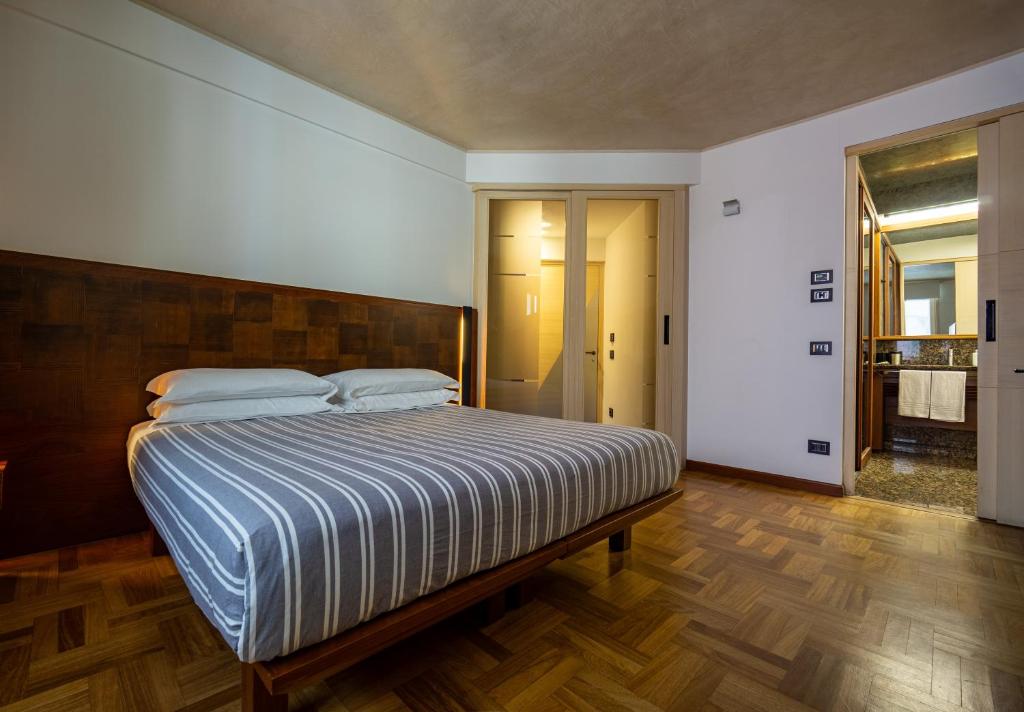 1 dormitorio con 1 cama grande y suelo de madera en Nicchia, en Verona