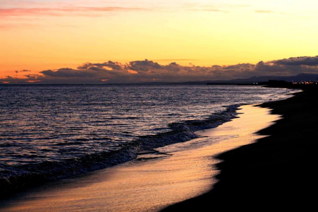 a view of the beach at sunset at T2 - Les pieds dans le sables en toutes saisons 5 couchages - climatisation - parking privée - piscine - situation optimum et rare - Amoureva - Plage Richelieu- Cap d'Agde in Cap d'Agde