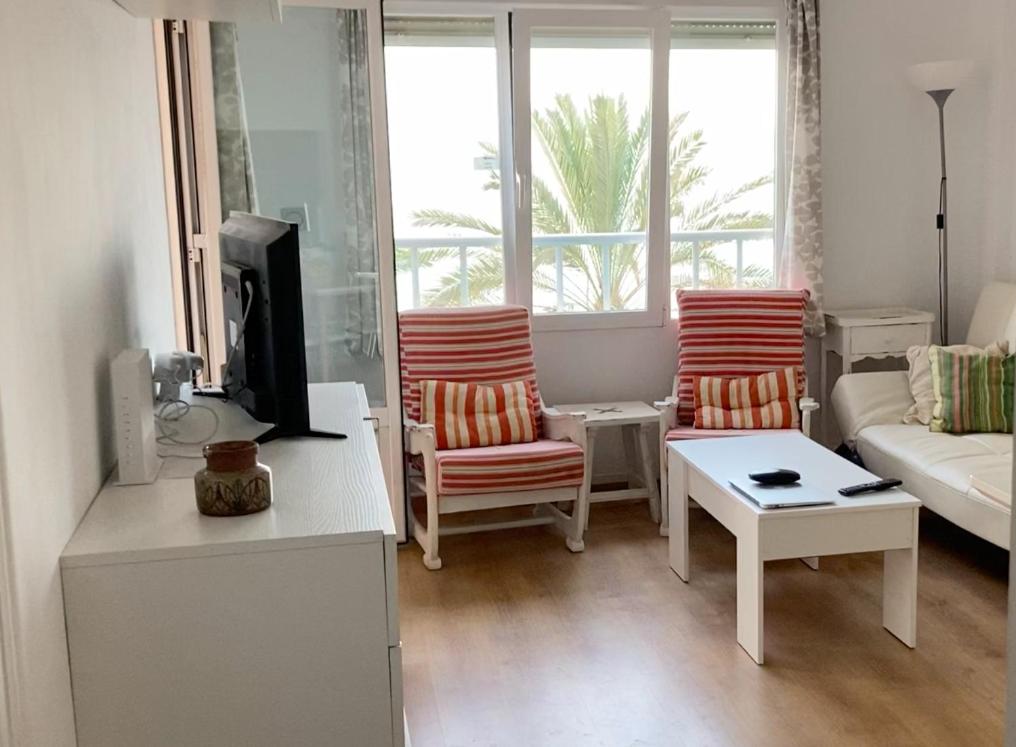ein Wohnzimmer mit 2 Stühlen und einem Sofa in der Unterkunft Apartamento 1ª linea de mar in Almería