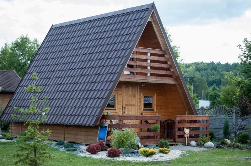una cabina in legno con tetto a foglia d'azzardo di Domki Niegowa a Niegowa