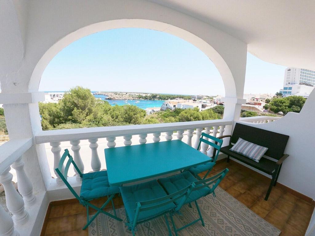 - Balcón con mesa azul y sillas en Apartamento 107 Castell Sol CB en Arenal d'en Castell