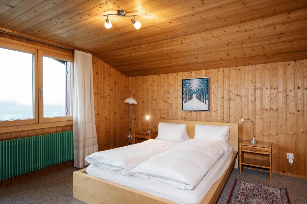 een slaapkamer met een bed in een houten kamer bij Apartment im Chalet Sidonie in Amden
