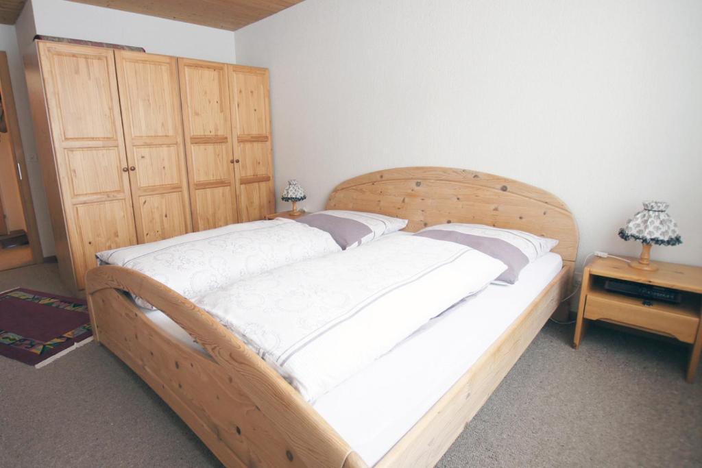 duże drewniane łóżko w pokoju z: w obiekcie Apartment Kaiser w mieście Amden