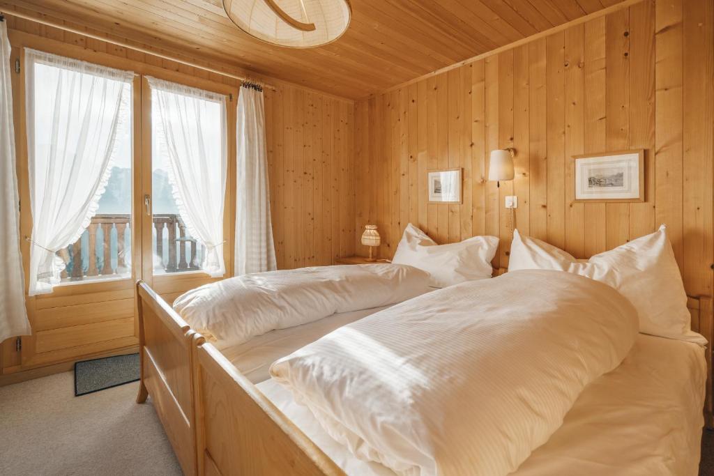 1 Schlafzimmer mit 2 Betten und einem Fenster in der Unterkunft Chalet Engihalde in Amden