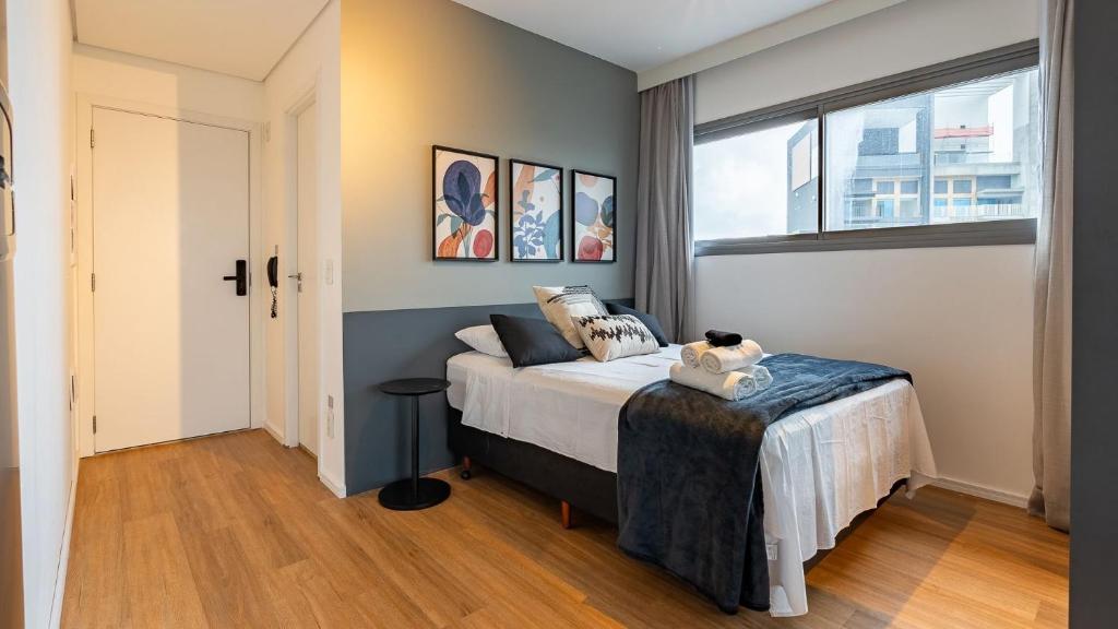 a bedroom with a bed and a window at Studio completo próx. estação Fradique Coutinho in Sao Paulo