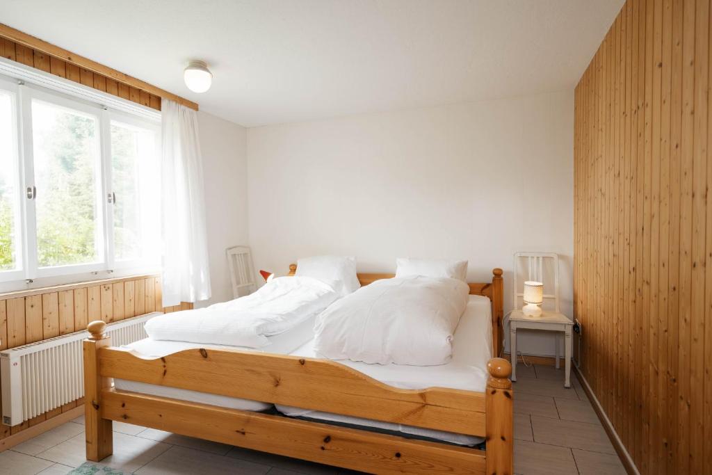 アムデンにあるApartment im Chalet Speerのベッドルーム1室(白い枕の木製ベッド1台付)