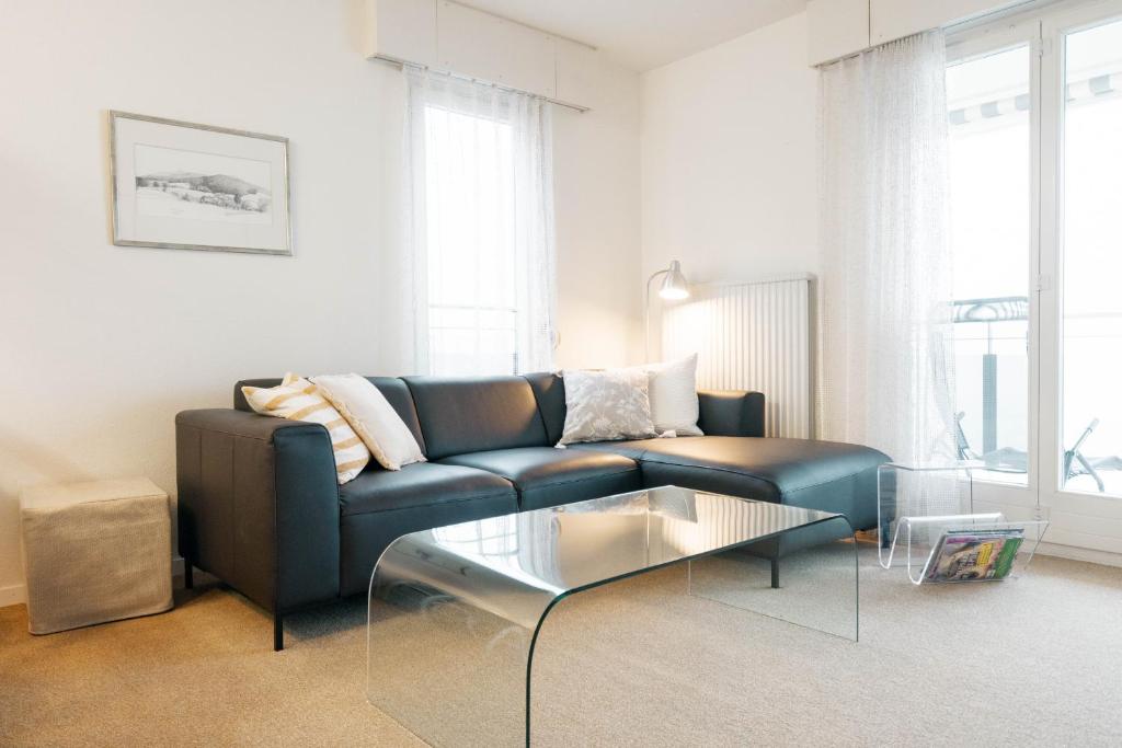 un salon avec un canapé bleu et une table en verre dans l'établissement Apartment Morgensonne, à Amden