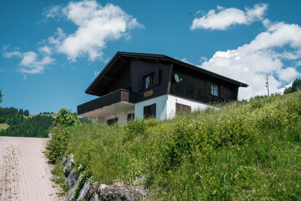 uma casa no topo de uma colina com uma estrada de terra em Chalet Theresia em Amden