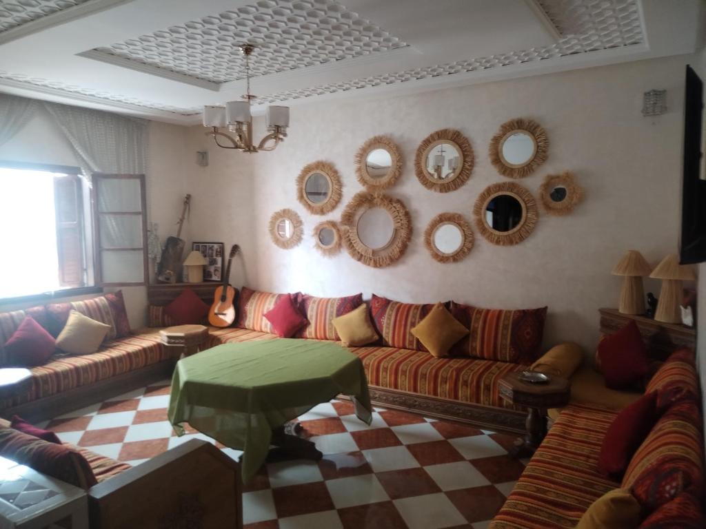 - un salon avec des canapés et des miroirs sur le mur dans l'établissement Hostel artistic airport, à Marrakech