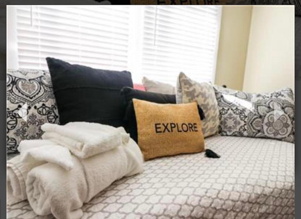 a couch with a pillow with the word explore on it at Old Bay All Day in Galveston