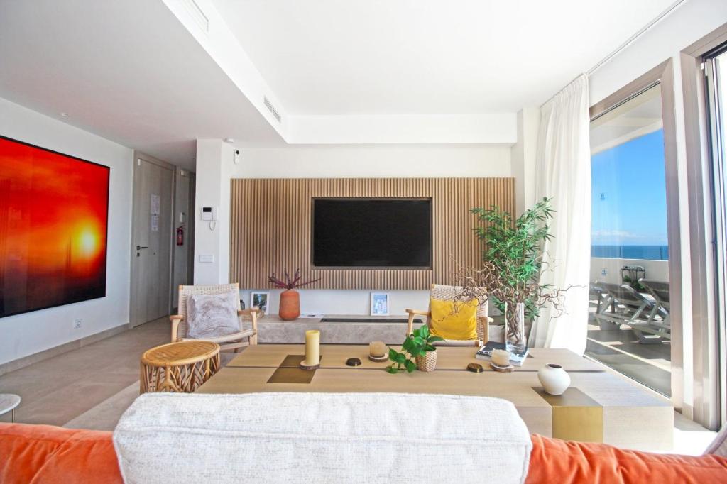 - un salon avec un canapé et une télévision dans l'établissement Apartment Aria By The Beach, à Los Pulpites
