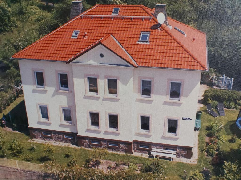uma grande casa branca com um telhado laranja em Ferienwohnung am Windberg em Freital