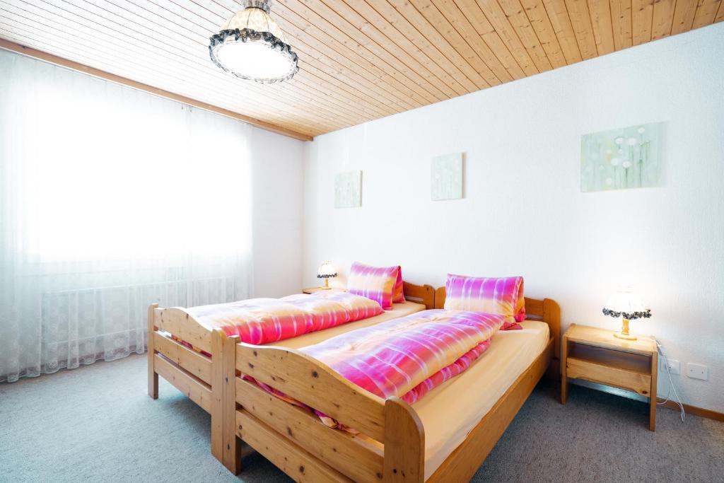1 Schlafzimmer mit 2 Betten und bunten Kissen in der Unterkunft Apartment Bischofberger D22 in Amden